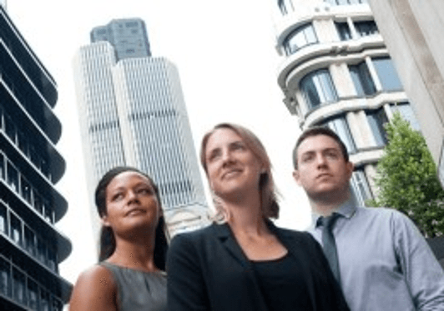 Three professionals in suits standing in front of towering skyscrapers, representing success and ambition in the business world.