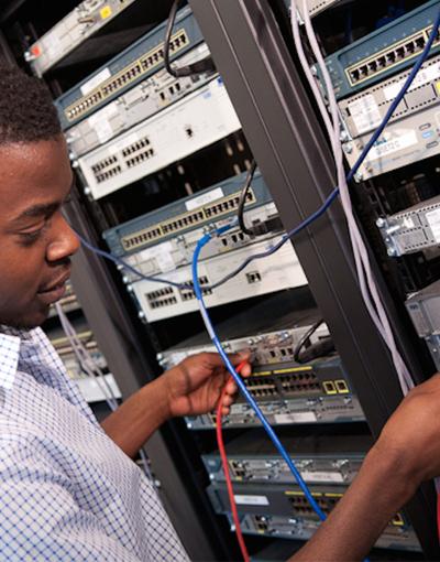 A man plugging a cable into a device