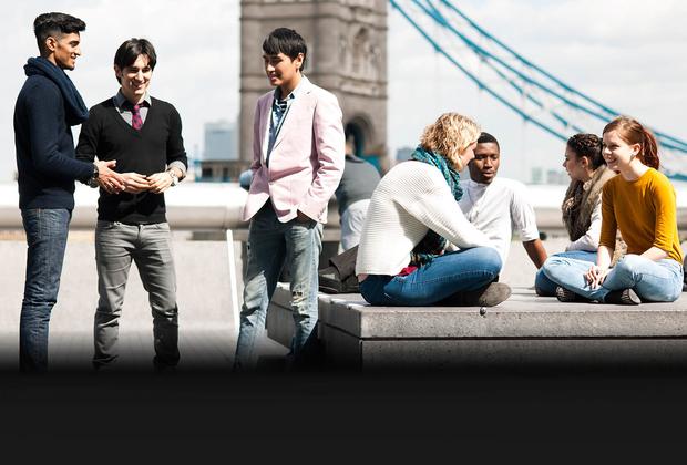 group students having conversation near tower bridge in London