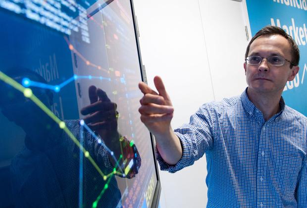 A lecturer pointing at a screen