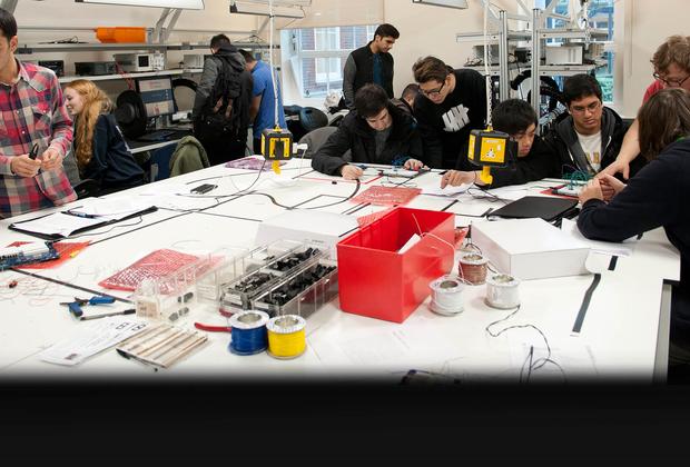 students work with circuit boards in busy laboratorys