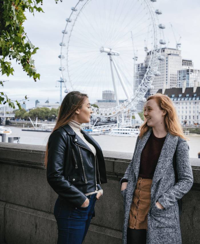 students by the river Thames, next to Westminster Bridge, London eye in the background